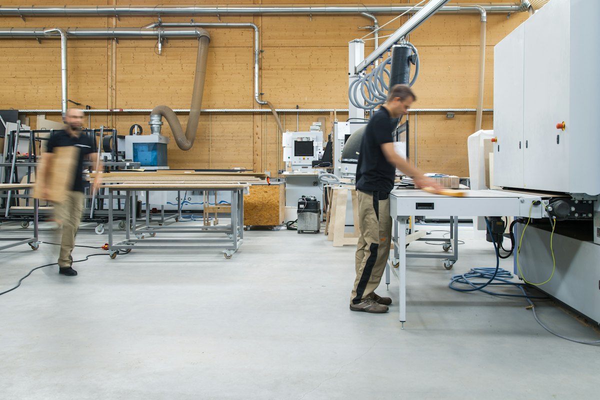 Atelier de production lumineux avec machines et opérateurs au travail